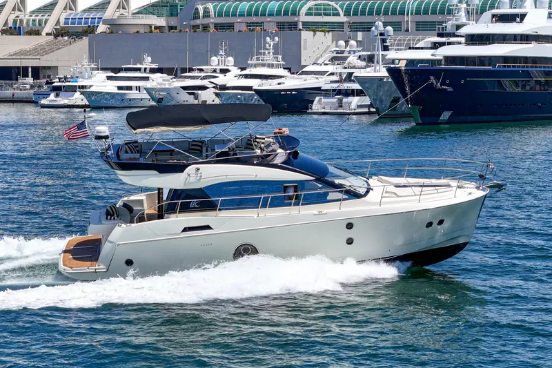 The Riviera Yacht Photos Pics 2017 Beneteau Monte Carlo 5 MC5 yacht cruising in a marina with other boats.