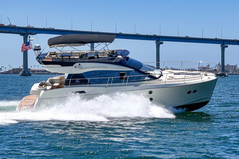The Riviera Yacht Photos Pics 2017 Beneteau Monte Carlo 5 MC5 yacht cruising under a bridge on a sunny day.