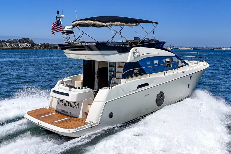 The Riviera Yacht Photos Pics 2017 Beneteau Monte Carlo 5 MC5 yacht cruising on open water, rear view.