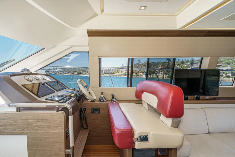The Riviera Yacht Photos Pics 2017 Beneteau Monte Carlo 5 MC5 yacht interior with helm, red seating, and scenic window view.