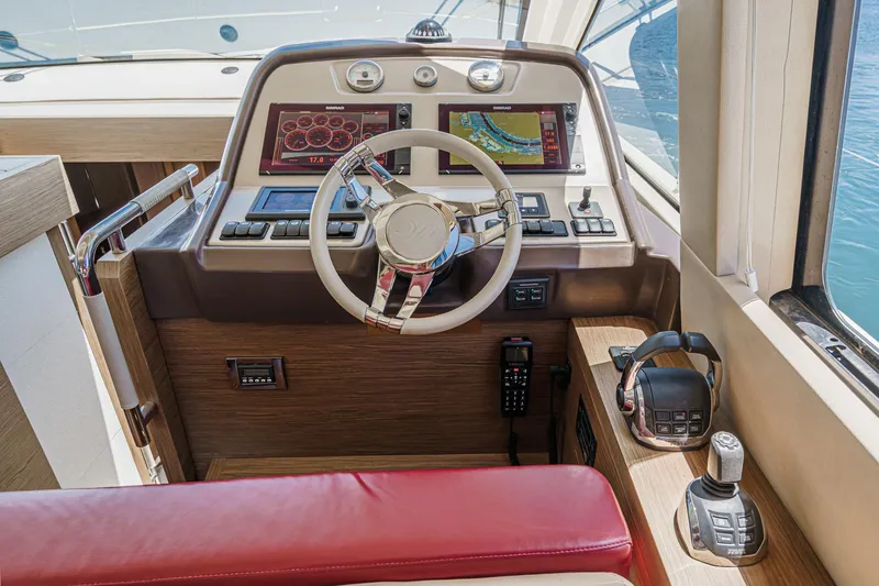 The Riviera Yacht Photos Pics Helm of 2017 Beneteau Monte Carlo 5 MC5 yacht with modern controls and red seating.