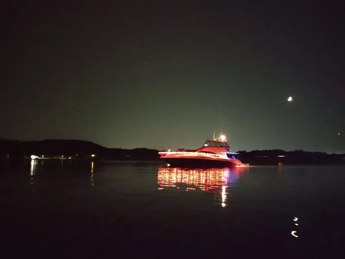 Cashed Out Yacht Photos Pics 2006 Sea Ray 58 Sedan Bridge yacht illuminated at night on calm water.