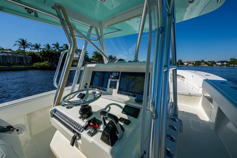  Yacht Photos Pics 2017 SeaVee 390Z boat cockpit with steering wheel and navigation screens, on a sunny day.