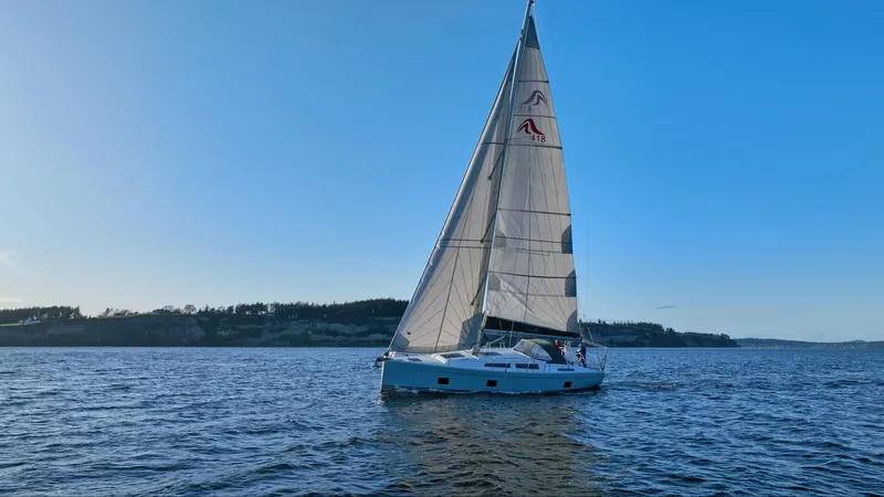 Dragon Fly Yacht Photos Pics 2019 Hanse 418 sailboat cruising on calm waters under a clear blue sky.