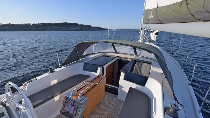 Dragon Fly Yacht Photos Pics 2019 Hanse 418 sailboat cockpit with seating, steering wheel, and open cabin on calm water.
