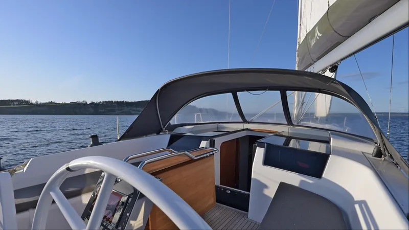 Dragon Fly Yacht Photos Pics 2019 Hanse 418 sailboat cockpit with steering wheel, canopy, and open sea view.