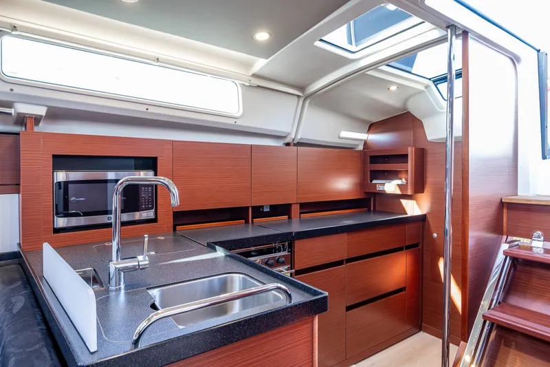 Dragon Fly Yacht Photos Pics Modern kitchen interior of 2019 Hanse 418 yacht with sleek wood cabinetry and stainless steel sink.