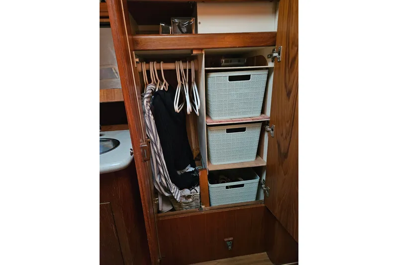 Solimar Yacht Photos Pics Wooden closet with hangers and storage baskets in a 2005 Hunter 41 AC boat.