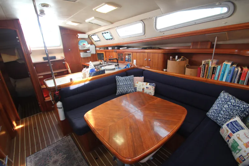 Solimar Yacht Photos Pics Interior of 2005 Hunter 41 AC sailboat with cozy seating and wooden table.
