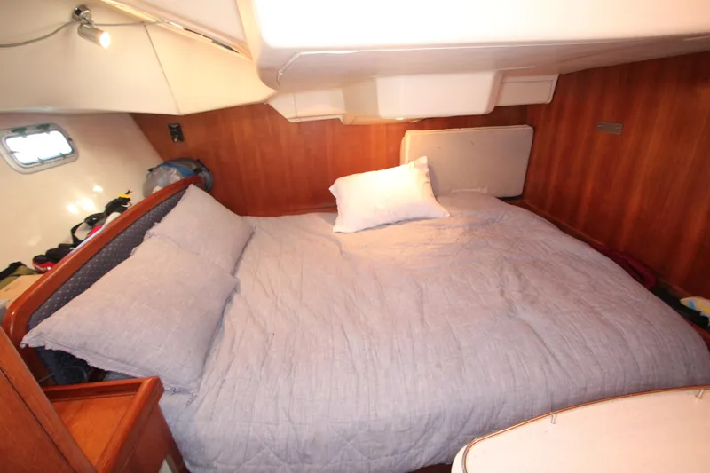 Solimar Yacht Photos Pics Cozy cabin bedroom in 2005 Hunter 41 AC sailboat with wooden interior and soft bedding.