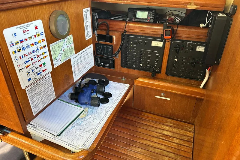Solimar Yacht Photos Pics Navigation station on 2005 Hunter 41 AC sailboat with charts, radio, and control panels.