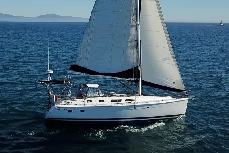 Solimar Yacht Photos Pics Sailing yacht Hunter 41 AC (2005) cruising on open sea with mountains in background.