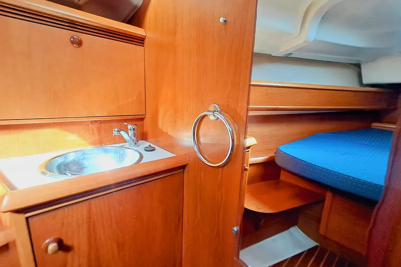  Yacht Photos Pics 2005 Jeanneau Sun Odyssey 40.3 yacht interior with wooden cabinetry and cozy sleeping area.