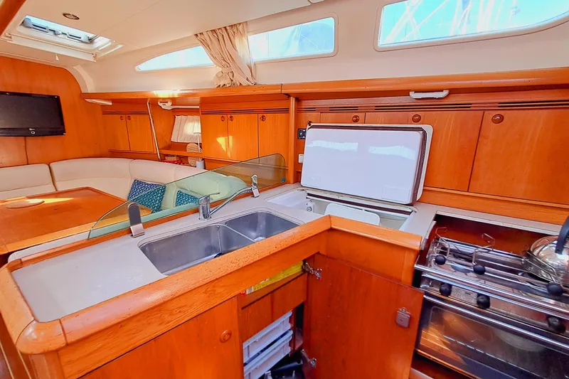  Yacht Photos Pics Interior of 2005 Jeanneau Sun Odyssey 40.3 yacht with kitchen and seating area.