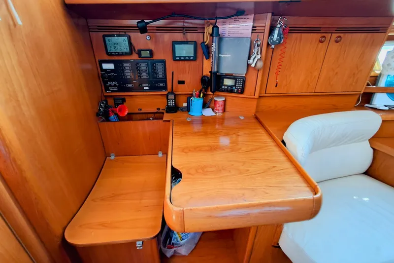  Yacht Photos Pics Interior of 2005 Jeanneau Sun Odyssey 40.3 yacht with navigation equipment and wooden finish.