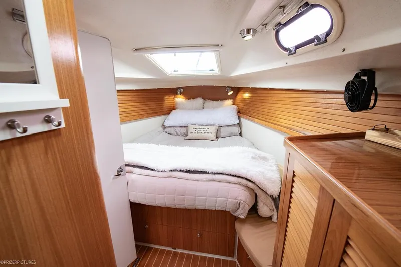Kinship Ll Yacht Photos Pics Cozy cabin interior of 2010 Catalina 445 sailboat with wooden accents and plush bedding.