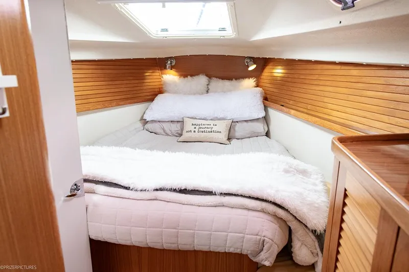 Kinship Ll Yacht Photos Pics Cozy cabin bedroom in 2010 Catalina 445 sailboat with wood paneling and plush bedding.