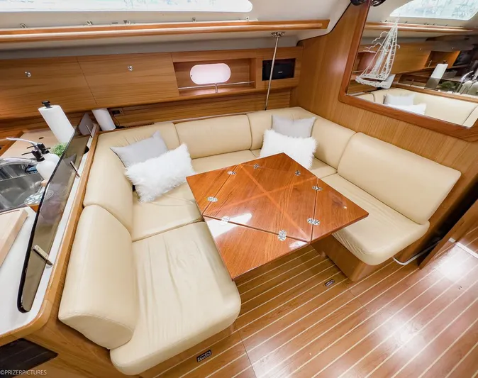 Kinship Ll Yacht Photos Pics Luxurious interior of 2010 Catalina 445 yacht with beige seating and wooden table.
