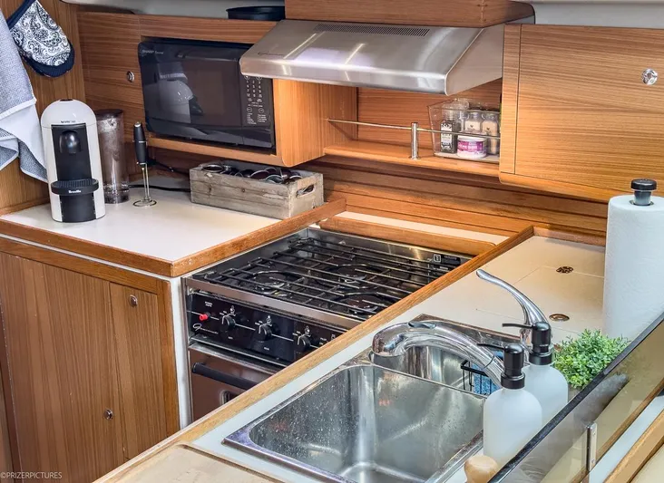 Kinship Ll Yacht Photos Pics Modern kitchen in a 2010 Catalina 445 yacht with stove, sink, and appliances.