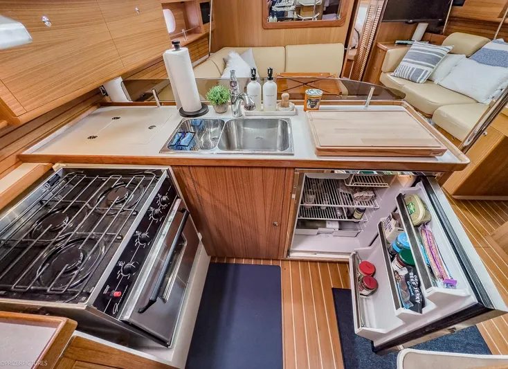 Kinship Ll Yacht Photos Pics Luxurious Catalina 445 yacht kitchen interior with stove, sink, and open fridge, showcasing modern amenities.