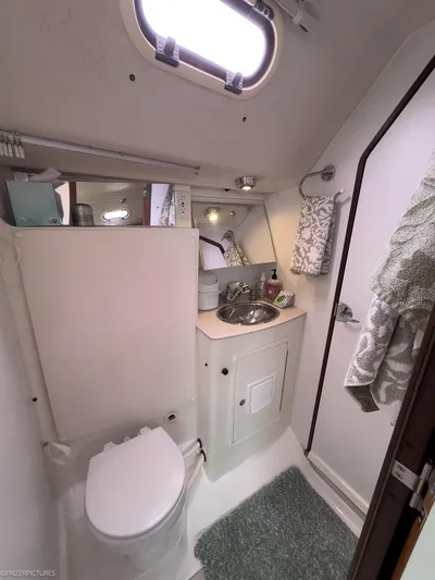Kinship Ll Yacht Photos Pics Compact bathroom in a 2010 Catalina 445 sailboat, featuring a toilet, sink, and mirror.