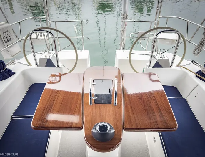 Kinship Ll Yacht Photos Pics Cockpit of 2010 Catalina 445 sailboat with dual steering wheels and wooden table.