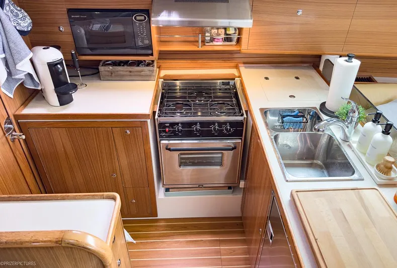 Kinship Ll Yacht Photos Pics Modern galley kitchen in 2010 Catalina 445 yacht with stove, sink, and microwave.