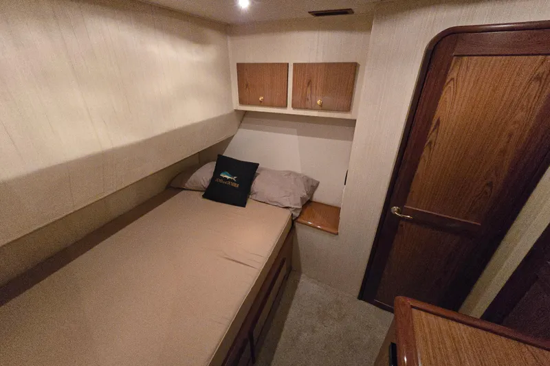  Yacht Photos Pics 1986 Ocean Yachts 55 Super Sport cabin with bed, wooden cabinets, and door.