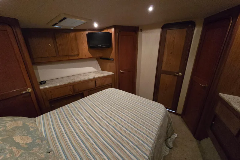  Yacht Photos Pics Interior of 1986 Ocean Yachts 55 Super Sport with cozy bedroom and wooden cabinetry.