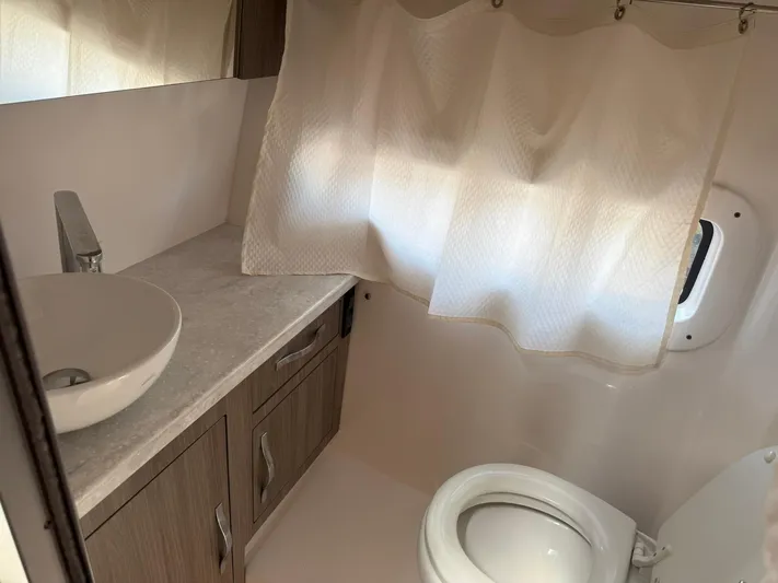  Yacht Photos Pics 2021 Regal 33 XO boat bathroom with sink, toilet, and curtain.
