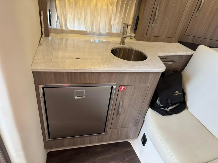 Yacht Photos Pics 2021 Regal 33 XO boat interior with kitchenette, sink, and compact fridge.