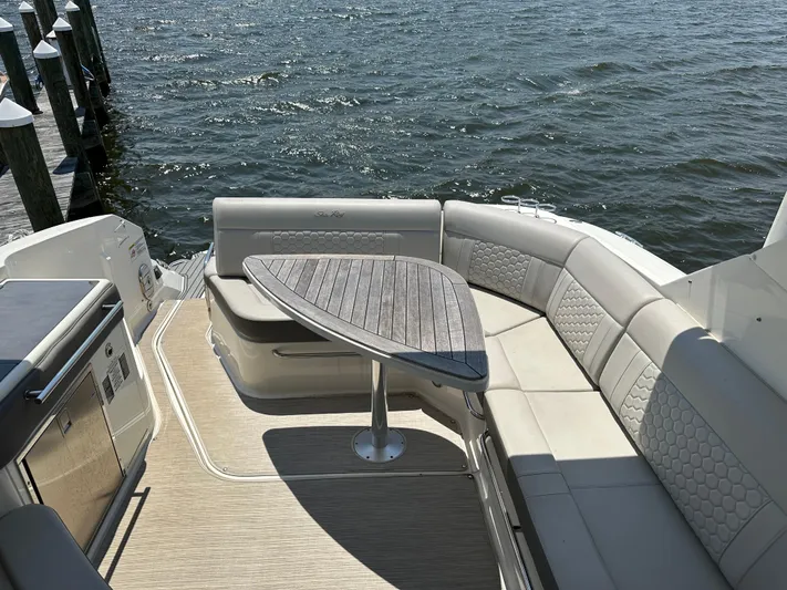  Yacht Photos Pics 2021 Sea Ray 320 Sundancer boat interior with elegant seating and table by the water.