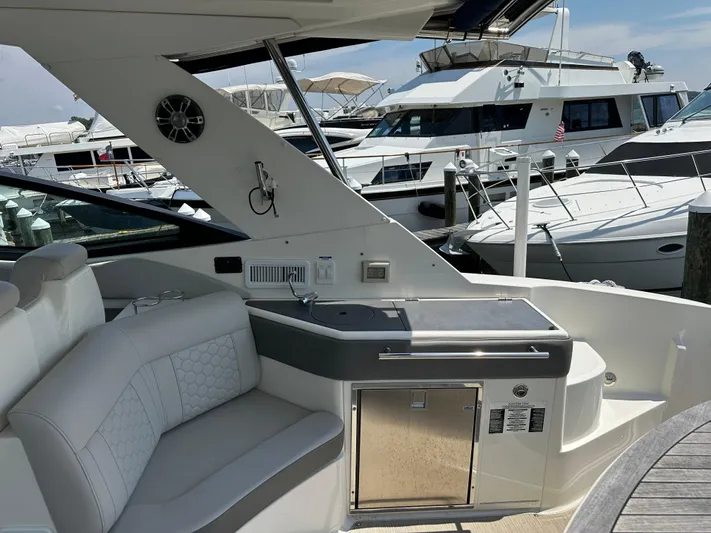  Yacht Photos Pics 2021 Sea Ray 320 Sundancer yacht interior with seating and kitchenette, docked at marina.