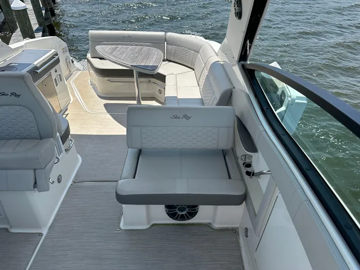  Yacht Photos Pics Luxurious 2021 Sea Ray 320 Sundancer boat interior with elegant seating and table by the water.