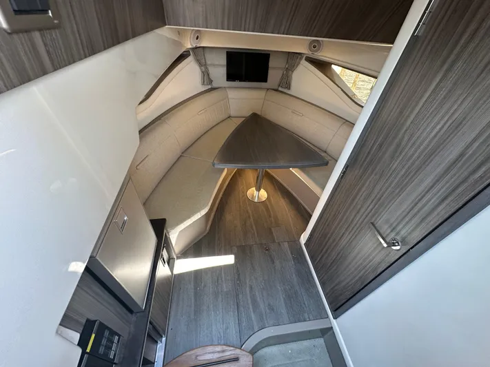  Yacht Photos Pics Interior of 2021 Sea Ray 320 Sundancer, featuring modern seating and table arrangement.
