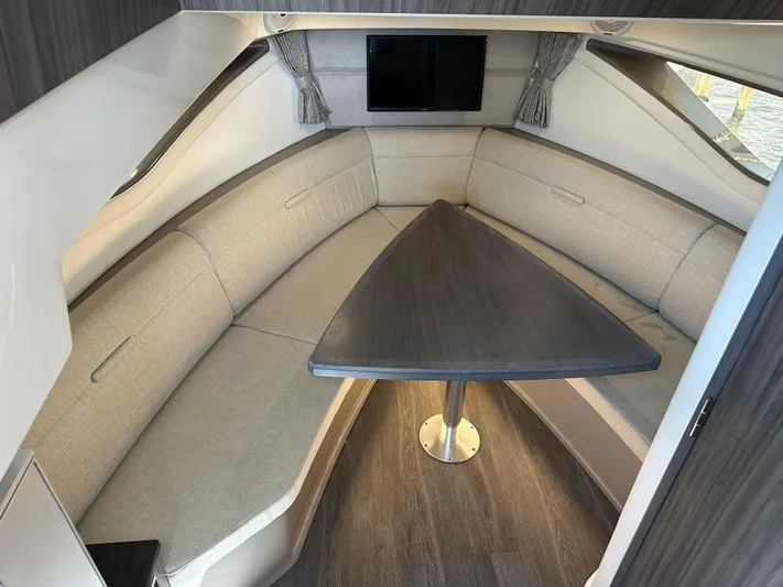  Yacht Photos Pics Interior of 2021 Sea Ray 320 Sundancer with cozy seating and triangular table.