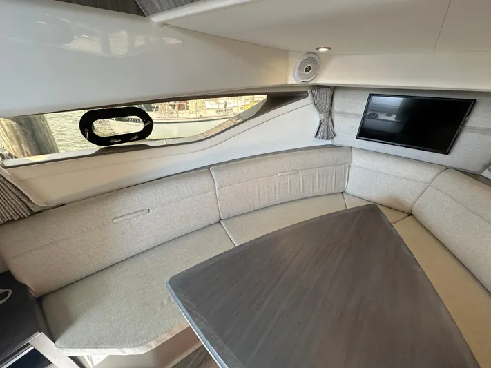  Yacht Photos Pics Luxurious interior of 2021 Sea Ray 320 Sundancer with plush seating and mounted TV.
