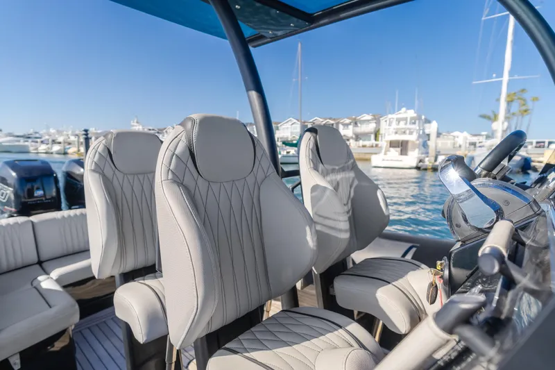  Yacht Photos Pics 2019 Technohull Sea DNA 999 boat interior with luxurious seating and steering wheel, docked at marina.