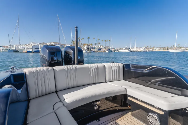  Yacht Photos Pics 2019 Technohull Sea DNA 999 boat interior with seating, docked in a marina under clear blue skies.