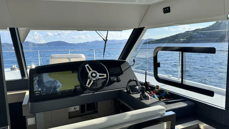 Pheonix Yacht Photos Pics Interior view of 2022 Fountaine Pajot MY6 yacht cockpit with ocean and island scenery.