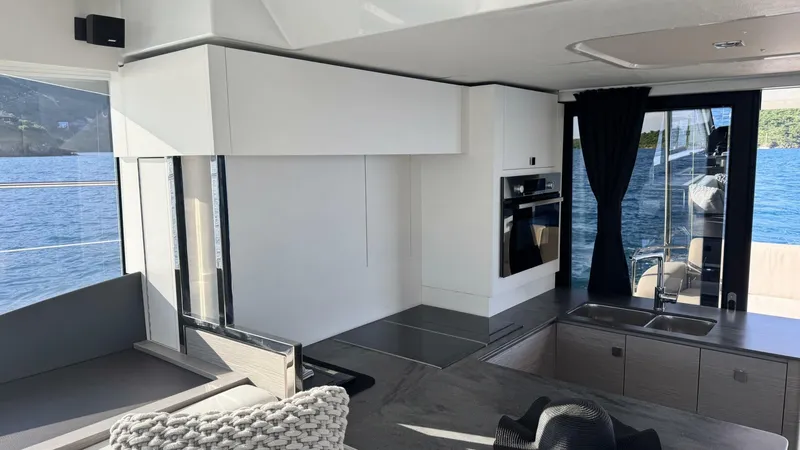 Pheonix Yacht Photos Pics Modern interior of 2022 Fountaine Pajot MY6 yacht with sleek kitchen and scenic water view.