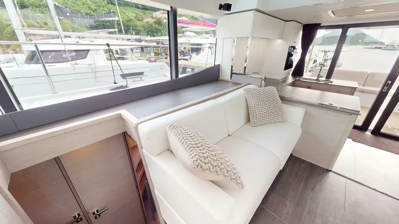 Pheonix Yacht Photos Pics Luxurious interior of 2022 Fountaine Pajot MY6 yacht with white seating and large windows.