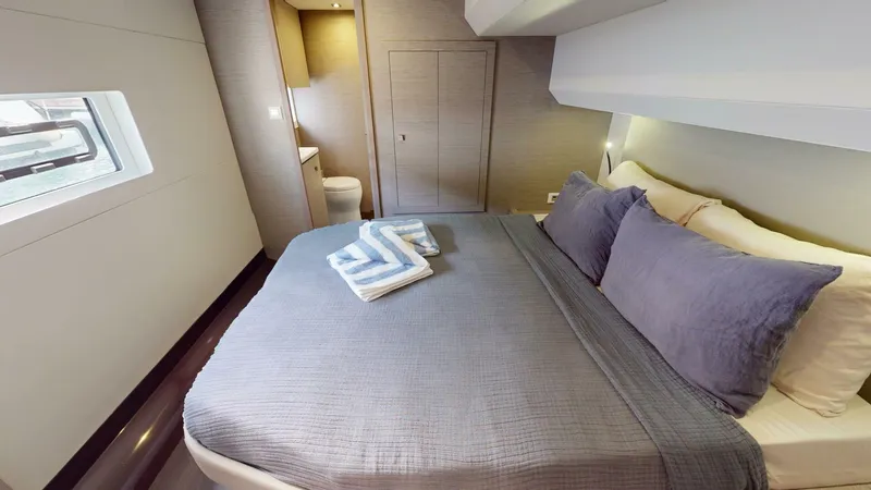 Pheonix Yacht Photos Pics Luxurious bedroom interior of 2022 Fountaine Pajot MY6 yacht with modern design and cozy bedding.