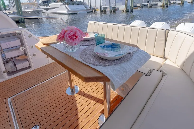  Yacht Photos Pics Luxurious dining setup on 2024 Hanover 415 Pure Gray yacht, featuring elegant tableware and pink flowers.