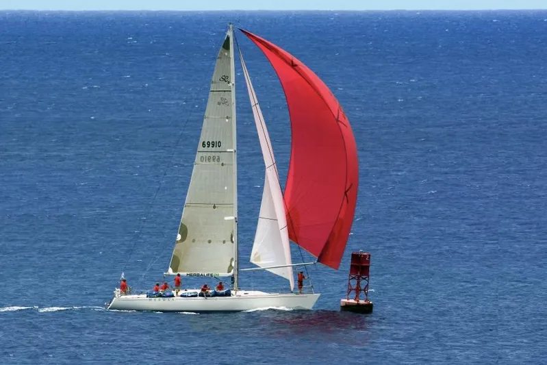 Medusa Yacht Photos Pics Santa Cruz 52 sailboat from 1996 with red spinnaker sailing near a buoy.