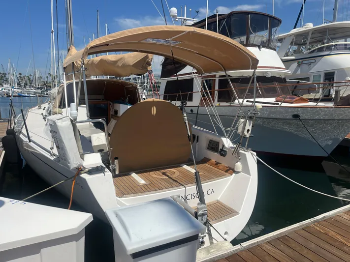 Medusa Yacht Photos Pics 1996 Santa Cruz 52 sailboat docked at marina, featuring tan canopy and wooden deck.
