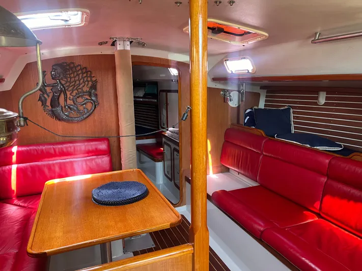 Medusa Yacht Photos Pics Interior of 1996 Santa Cruz 52 yacht with red seating and wooden accents.