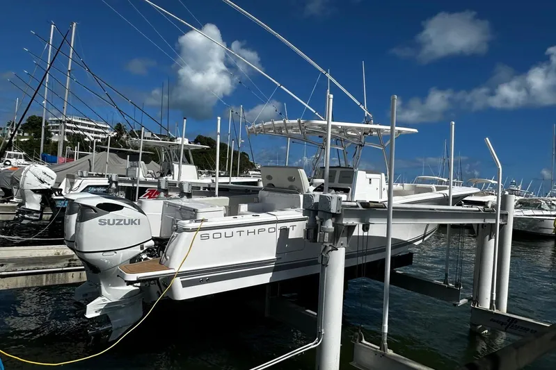  Yacht Photos Pics 2022 Southport 30 FE boat docked with Suzuki outboard motor, under clear blue sky.
