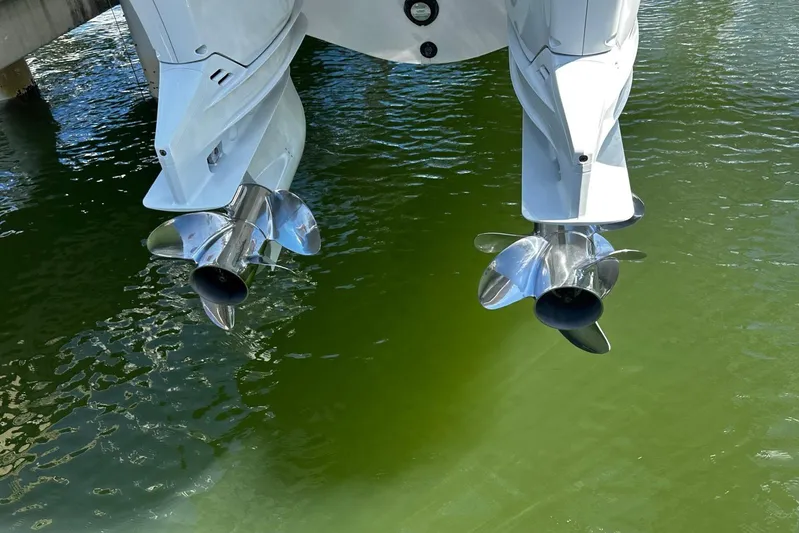  Yacht Photos Pics Twin outboard motors of a 2022 Southport 30 FE boat above green water.