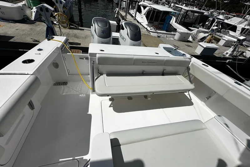  Yacht Photos Pics 2022 Southport 30 FE boat interior with seating and dual outboard engines at dock.